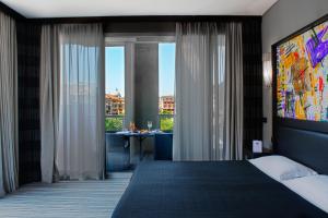 1 dormitorio con cama grande y ventana grande en Twentyone Hotel, en Roma