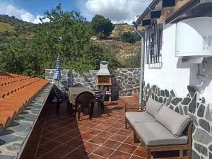 Casa Rural La Higuera 2 في لا خويا: فناء مع أريكة وطاولة وكراسي