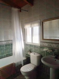 a bathroom with a toilet and a sink and a window at Casa Rural La Higuera 2 in La Joya