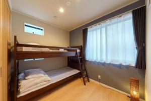 sypialnia z 2 łóżkami piętrowymi i oknem w obiekcie YADOYA 上野離宮 w Tokio