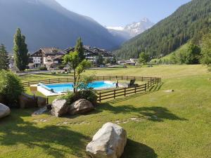 una piscina in un campo con montagne sullo sfondo di Appartamento condominio Ametista - La Thuile a La Thuile