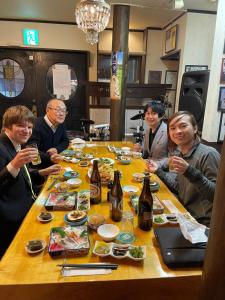 un grupo de personas sentadas alrededor de una mesa comiendo comida en Live Cafe Hisui no Umi, en Itoigawa