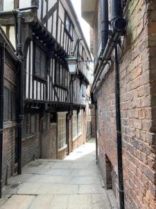 an alley in an old building with black and white buildings at Joseph's Loft in York