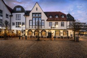 a large white building with a courtyard in front of it at Boutique Hotel Melchers in Vechta