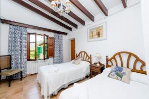 sypialnia z dwoma łóżkami i oknem w obiekcie Casa Margarita bis, casa con pisicina en Fornalutx w mieście Fornalutx +8 zdjęć