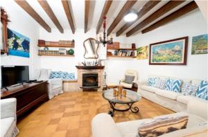 een woonkamer met witte meubels en een open haard bij Casa Margarita bis, casa con pisicina en Fornalutx in Fornalutx
