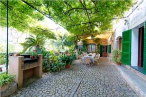 patio ze stołem, krzesłami i roślinami w obiekcie Casa Margarita bis, casa con pisicina en Fornalutx w mieście Fornalutx