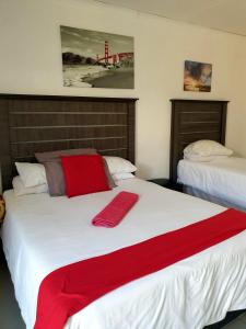 a bedroom with two beds with red blankets on them at Rose Guesthouse Klerksdorp in Klerksdorp