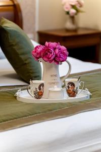 a tray with two cups and a vase with flowers at Central Harmony Apartment in Odorheiu Secuiesc