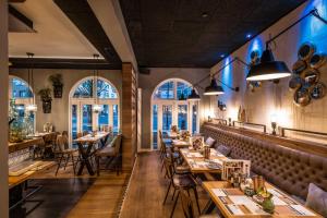 a restaurant with tables and chairs and windows at Boutique Hotel Melchers in Vechta