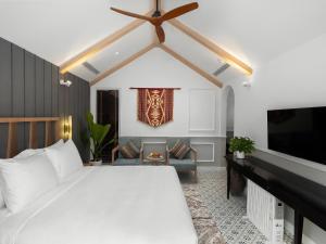 1 dormitorio con 1 cama blanca y TV en Golden Boutique Hotel Mang Den en Kon Tum (2)