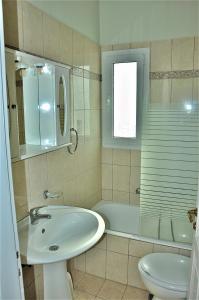a bathroom with a sink and a tub and a toilet at Sea Wave Villa Kefaloniaprivatevillas in Trapezaki