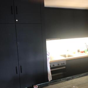 a kitchen with black cabinets and a sink and a window at Petit Appart de Charme Eau chaude solaire Rénovation 2021 Wifi disponible Belvedere 5 in Saint-Luc