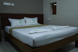 Postel nebo postele na pokoji v ubytování The Ideal Nest Kumbakonam
