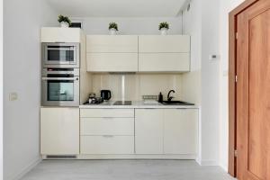 ソポトにあるLion Apartments - Bright Sideの白いキッチン(白いキャビネット、電化製品付)
