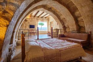 ein Schlafzimmer mit einem Bett und einer Couch in der Unterkunft Avanos Evi in Avanos