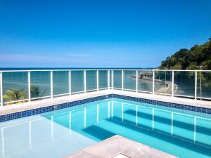 a swimming pool with a view of the ocean at BLUE SUNSET PREMIUM - Flat Beira Mar para até 5 pessoas - Cabo Branco - Piscina Rooftop in João Pessoa