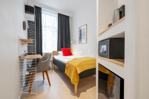 
a bedroom with a bed and a television at Go Hotel Ansgar in Copenhagen
