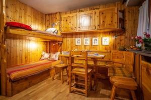 a bedroom with a bunk bed and a table and chairs at Casa-chalet, in centro a Courmayeur! in Courmayeur