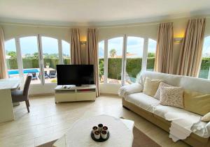 a living room with a white couch and a television at CostaBlancaDreams Casa Cuxarret in Calpe in Casas de Torrat