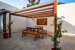 a patio with a wooden pergola and a table and benches at Takshshila Park And Resorts in Jagdalpur
