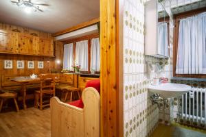 baño con lavabo y cocina con mesa. en Casa-chalet, in centro a Courmayeur!, en Courmayeur 13 fotos más