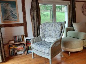 ein Stuhl in einem Wohnzimmer mit Fenster in der Unterkunft Poza Czasem in Bystrzyca Kłodzka