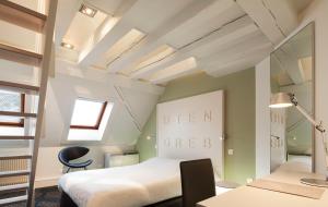 a bedroom with a bed and a desk and a chair at Hôtel Gutenberg in Strasbourg
