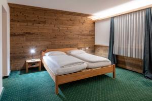 Un pat sau paturi într-o cameră la Hotel Grischuna