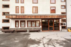 un edificio con bancos frente a un edificio en Casa-chalet, in centro a Courmayeur!, en Courmayeur