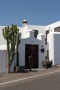 un edificio blanco con una puerta y un cactus en Las Pérgolas Villa Rural en Tías