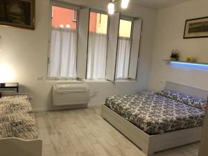 a bedroom with a bed and two windows at Appartamento House Apartment Tabe Centro Bologna in Bologna