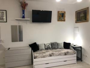 salon z kanapą i telewizorem na ścianie w obiekcie Appartamento House Apartment Tabe Centro Bologna w Bolonii
