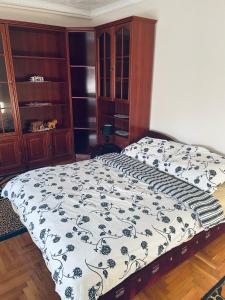 a bedroom with a bed with a black and white comforter at Törpi Apartman in Halmaj
