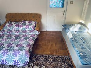 a small bedroom with a bed and a door at Törpi Apartman in Halmaj