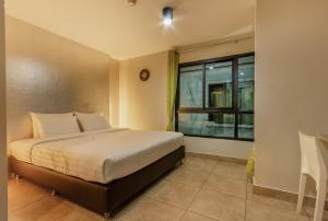 um quarto com uma cama e uma janela em Matini Ratchada 32 em Banguecoque