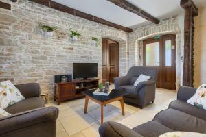 Una sala de estar con dos sillas y un televisor. en Villa Paulina -an authentic sense of Istrian life, en Gajana