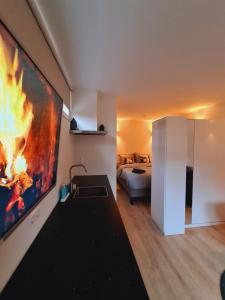 una sala de estar con una pintura de fuego en la pared en Studio Baarn with patio, airco, pantry, bedroom, bathroom, privacy - Amsterdam, Utrecht, en Baarn