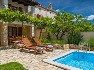 Un patio con dos sillas y una piscina. en Villa Paulina -an authentic sense of Istrian life, en Gajana