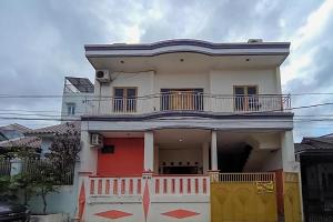 Casa blanca con balcón en la parte superior. en KoolKost Syariah At Komplek PLN Balikpapan, en Balikpapan
