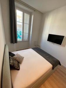 1 dormitorio con 1 cama y TV de pantalla plana en LEC2-3 Pièces rénové - Centre Ville, en Cannes