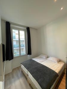 1 dormitorio con cama y ventana en LEC2-3 Pièces rénové - Centre Ville, en Cannes