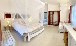 a bedroom with two beds with mosquito nets in it at Gecko Resort in Watamu