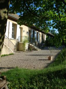 a house with a gravel driveway in front of it at Les Communs du Manoir in Écully