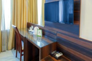 a hotel room with a desk with a tv and a table at Hotel Dreamland Chandigarh in Chandīgarh