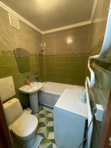 ein grünes Bad mit einem WC und einem Waschbecken in der Unterkunft 2-х комнатная Ауезова in Öskemen