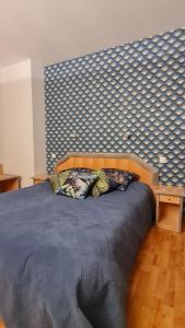 ein Schlafzimmer mit einem großen Bett mit blauer Wand in der Unterkunft La casa color in Lamagdelame