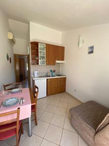 a kitchen with a table and a dining room at Apartmani Marija in Molat