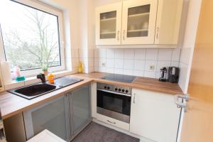 a kitchen with white cabinets and a sink and a window at FullHouse - Dessau - K36 Classic - Balcony in Dessau