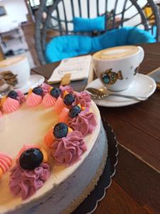 a cake sitting on a table with a cup of coffee at Penzion jako víno in Bulhary